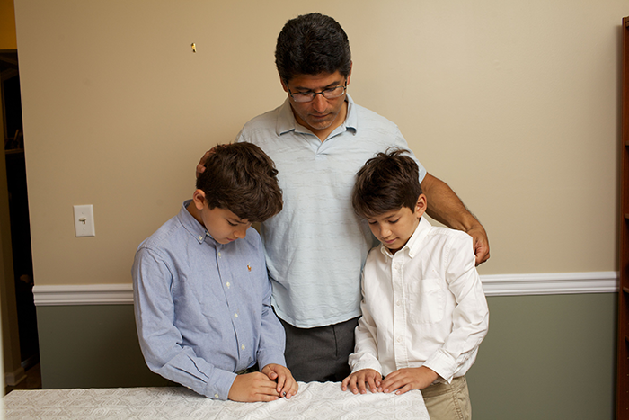 Photo of a father with his arms around two boys